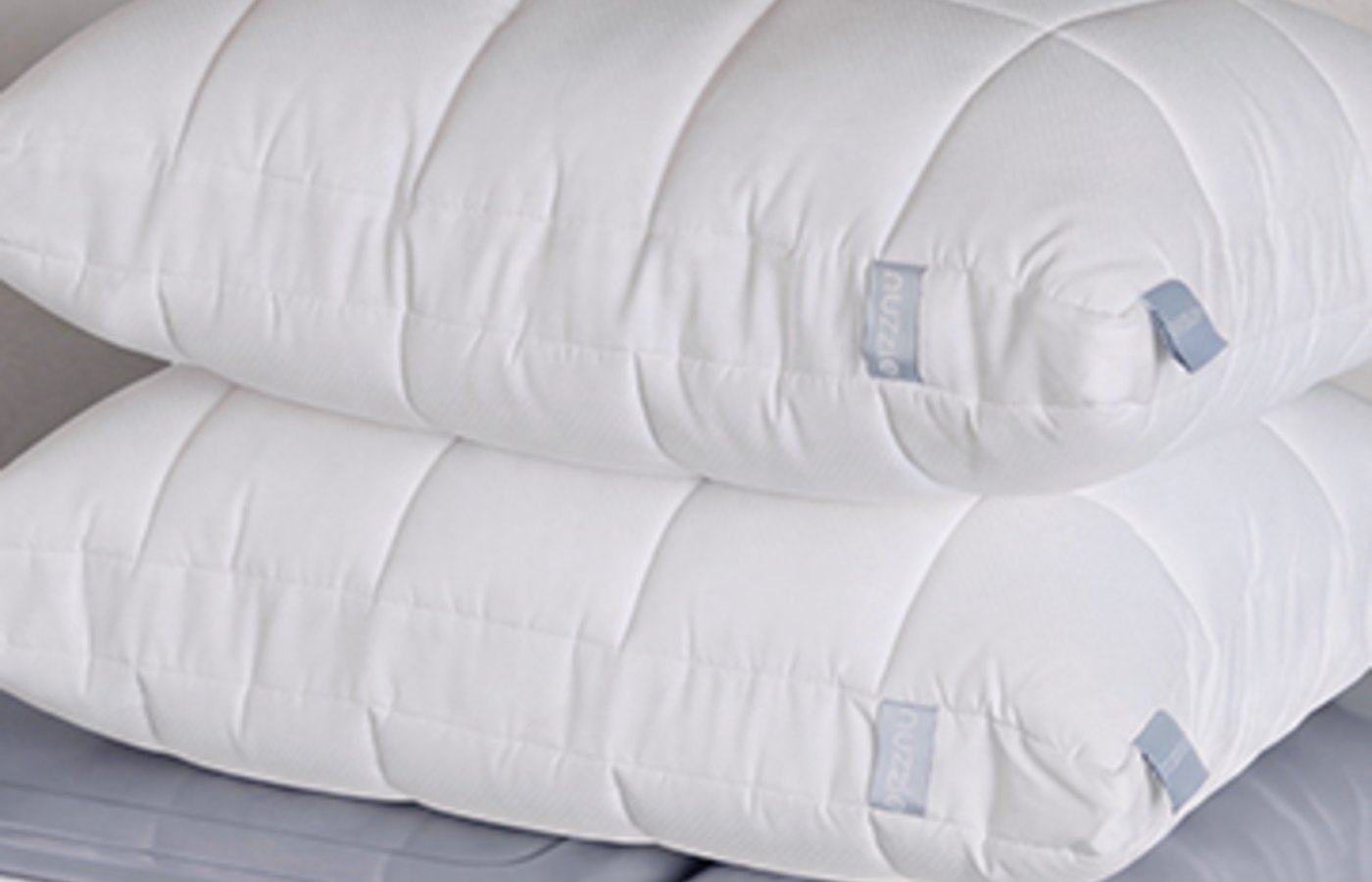 Nuzzle pillows folded beside a washing machine